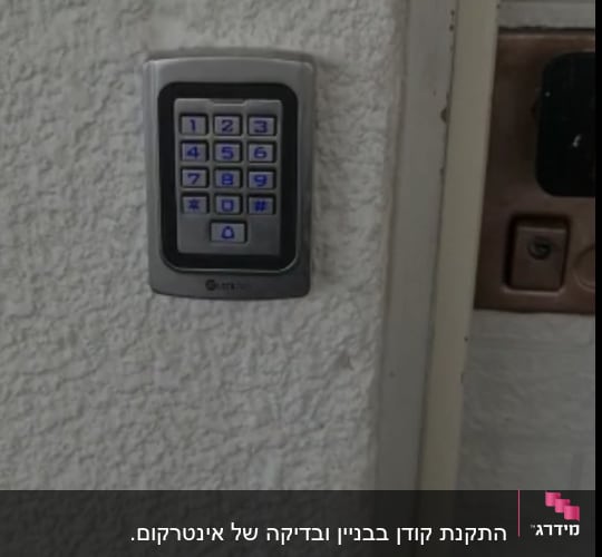 לוח מקשים של אינטרקום על קיר לבן